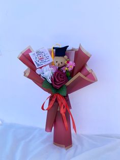 a bouquet of flowers with a teddy bear on top