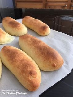 four loaves of bread sitting on top of a white paper towel next to an oven