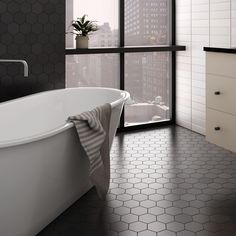 a white bath tub sitting in a bathroom next to a window