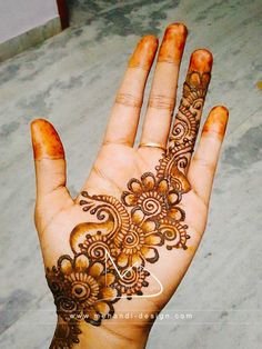 the hand is decorated with henna and flowers on it's palm, as well as an intricate design