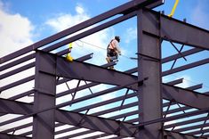 a man on a skateboard is working on the metal structure that's being built