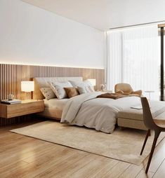 a large bed sitting next to a tall window in a bedroom on top of a hard wood floor