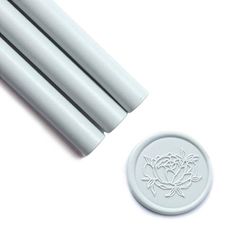 four white candles sitting on top of a table next to a wax stick and stamp