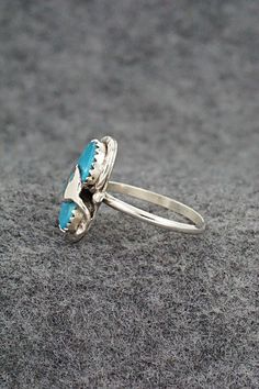 This turquoise and sterling silver ring was made by Zuni silversmith Joy Calavaza. The back is signed Effie C and Zuni.Size: 7.5Length: 3/4"Width: 1/2"Free shipping on all orders! We ship with USPS and always include tracking. All orders ship within a day of payment.Returns are accepted up to 30 days after you receive your order. Just send us a message. Our shop offers cash back or store credit. The item must be returned in new condition. Southwestern Sterling Silver Turquoise Ring For Anniversary, Stamped 925 Turquoise Ring For Wedding, Wedding Turquoise Ring Stamped 925, Southwestern Sterling Silver Turquoise Ring, Oval Turquoise Ring With Sterling Silver Inlay, Untreated Turquoise Sterling Silver Ring, Untreated Turquoise Sterling Silver Ring For Anniversary, Untreated Turquoise Ring In Sterling Silver For Anniversary, Hallmarked Turquoise Sterling Silver Ring For Anniversary