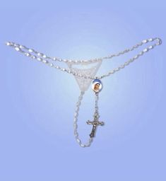 a white beaded necklace with a cross on it