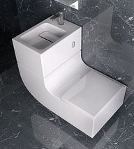 a white toilet sitting on top of a bathroom floor next to a wall mounted sink