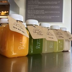 six bottles of juice are lined up on the counter