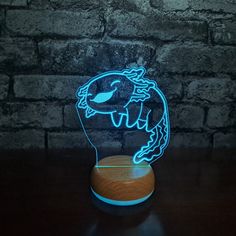 a blue neon sign with a fish on it sitting in front of a brick wall