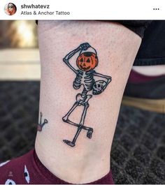 a person with a skeleton tattoo on their leg, holding a jack - o'- lantern