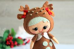 a small doll is dressed in brown and white polka dot fabric with deer ears on it's head