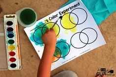 a child is painting with watercolors on paper