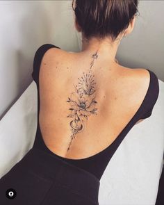 a woman with a flower tattoo on her back