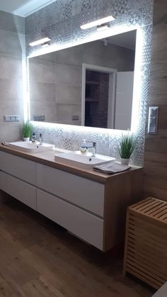 a bathroom with two sinks and a large mirror on the wall over it's counter