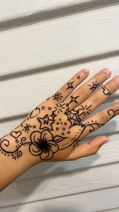 a woman's hand with hendix on it and stars around the wrist