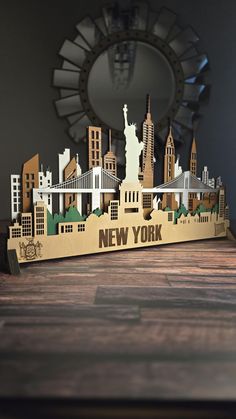 the new york skyline is cut out of wood and sits on a table in front of a mirror