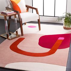 an area rug with pink, orange and white designs on it in front of a window