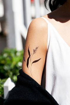 a woman's arm with a tattoo on it that has a plant growing out of it