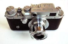 an old fashioned camera sitting on top of a white table