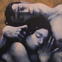 a man and woman laying next to each other in front of a painting on the wall