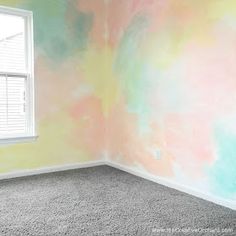 an empty room painted in pastel colors with a window on the far wall and carpeted floor