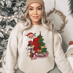 Embrace the yuletide spirit with our 'Whimsical Festive AF' holiday sweatshirt! Featuring playful Santa, snowman, and leopard-print tree graphics, this cozy sweatshirt is your perfect companion for cheerful winter days. Available in various colors and sizes exclusively on our website. Lovingly crafted by our dedicated small business, bringing you comfort and festive vibes all season long. **Product Details - Unisex, crewneck sweatshirt - 50/50 cotton and polyester - For best fit and color choice Relaxed Fit Holiday Sweatshirt For Fall, Holiday Graphic Print Sweater For Fall, Holiday Graphic Print Cotton Sweatshirt, Holiday Cotton Sweatshirt With Graphic Print, Christmas Graphic Print Relaxed Fit Sweatshirt, Holiday Cotton Sweater With Graphic Print, Relaxed Fit Christmas Sweater With Graphic Print, Christmas Sweater With Graphic Print And Relaxed Fit, Holiday Sweatshirt