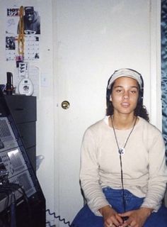 a woman sitting on the floor with headphones in her ears