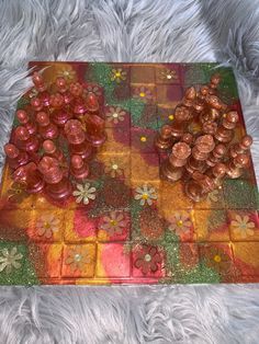 a close up of a board game on a furry surface with flowers and leaves painted on it