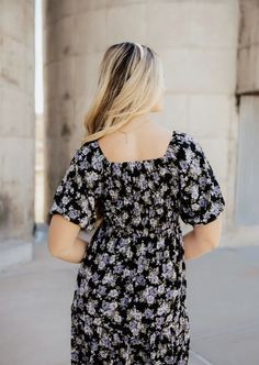 a woman wearing a black and white floral print dress