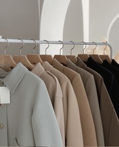 several coats hanging on a rack in a clothing store, with one coat folded open and the other closed