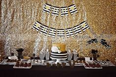 a table topped with cake and desserts under a gold sequin backdrop