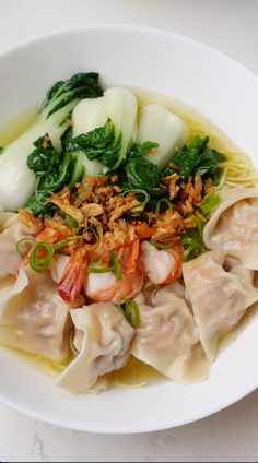 a white plate topped with dumplings and veggies