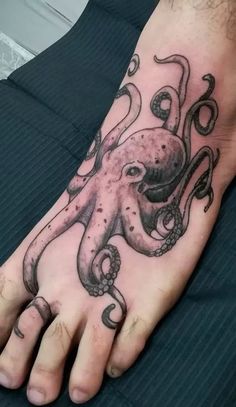 an octopus tattoo on the foot of a man's left hand with black ink