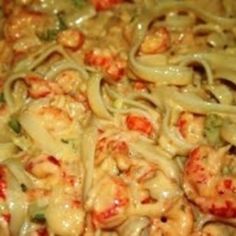 some noodles and shrimp are mixed together in a sauce that is ready to be eaten