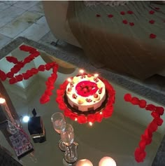 a white cake with red icing sitting on top of a table next to candles