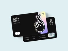 two black and white credit cards with lucky card stickers on the front one has an image of a hand holding a peace sign