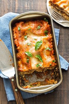 lasagna casserole with cheese and herbs in a baking dish on a wooden table