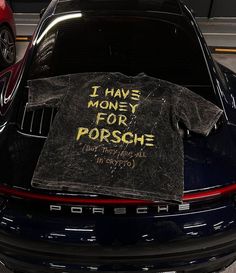 a t - shirt that says i have money for porsche sits on the hood of a car