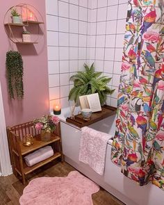 a bathroom with pink walls and flooring next to a white bath tub filled with towels