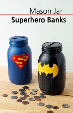 two mason jars with batman and superman symbol on them, next to some pennies