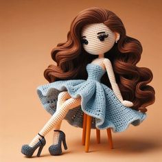 a crocheted doll sitting on top of a chair with her legs spread out