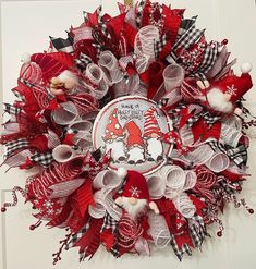 a red and white christmas wreath with gnomes on it