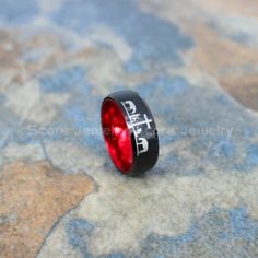 a black ring with the word faith on it sitting on top of a stone surface