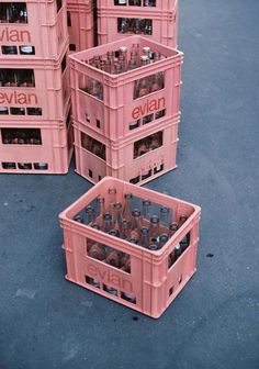 several pink crates with bottles in them stacked on top of each other and labeled evian