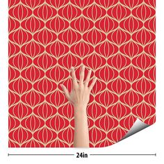 a hand reaching up against a red wallpaper with an intricate pattern on the side