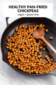 healthy pan fried chickpeas in a skillet with a wooden spoon