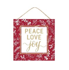 a red and white sign that says peace love joy with gold foil lettering on it