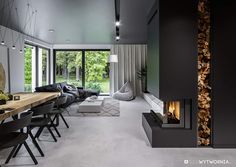 a living room filled with furniture and a fire place next to a dining room table