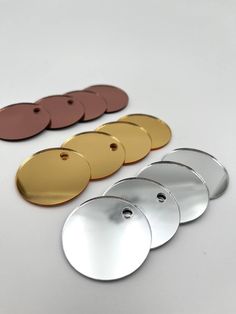 four discs are shown next to each other on a white surface with gold, silver, and brown circles