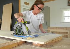 a woman using a circular saw to cut plywood