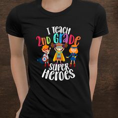 a woman wearing a black t - shirt that says i teach 2nd grade super heros